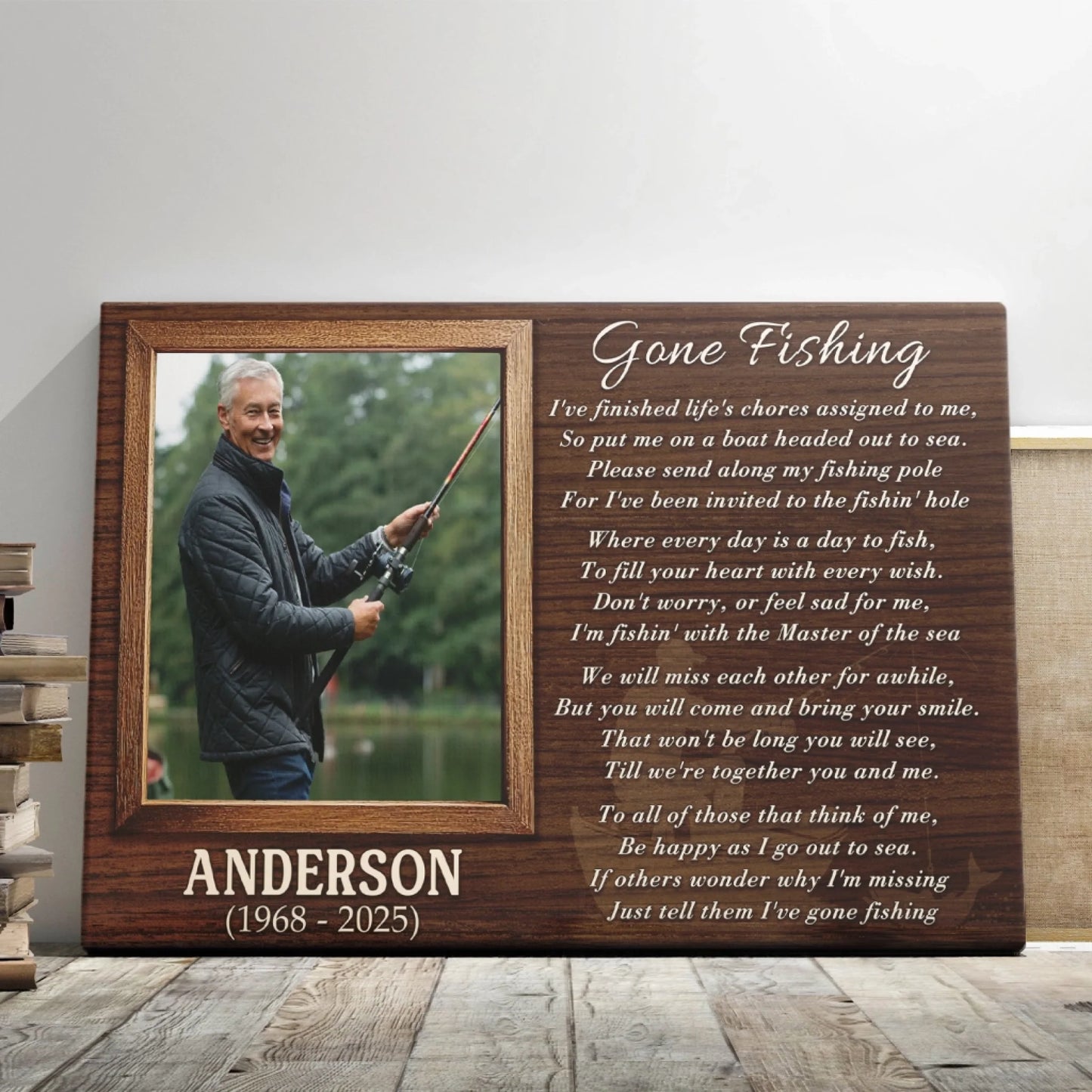 A wooden plaque features a framed photo of a man fishing, dates '1968 - 2025', and a 'Gone Fishing' poem, leaning on a light wall next to books.
