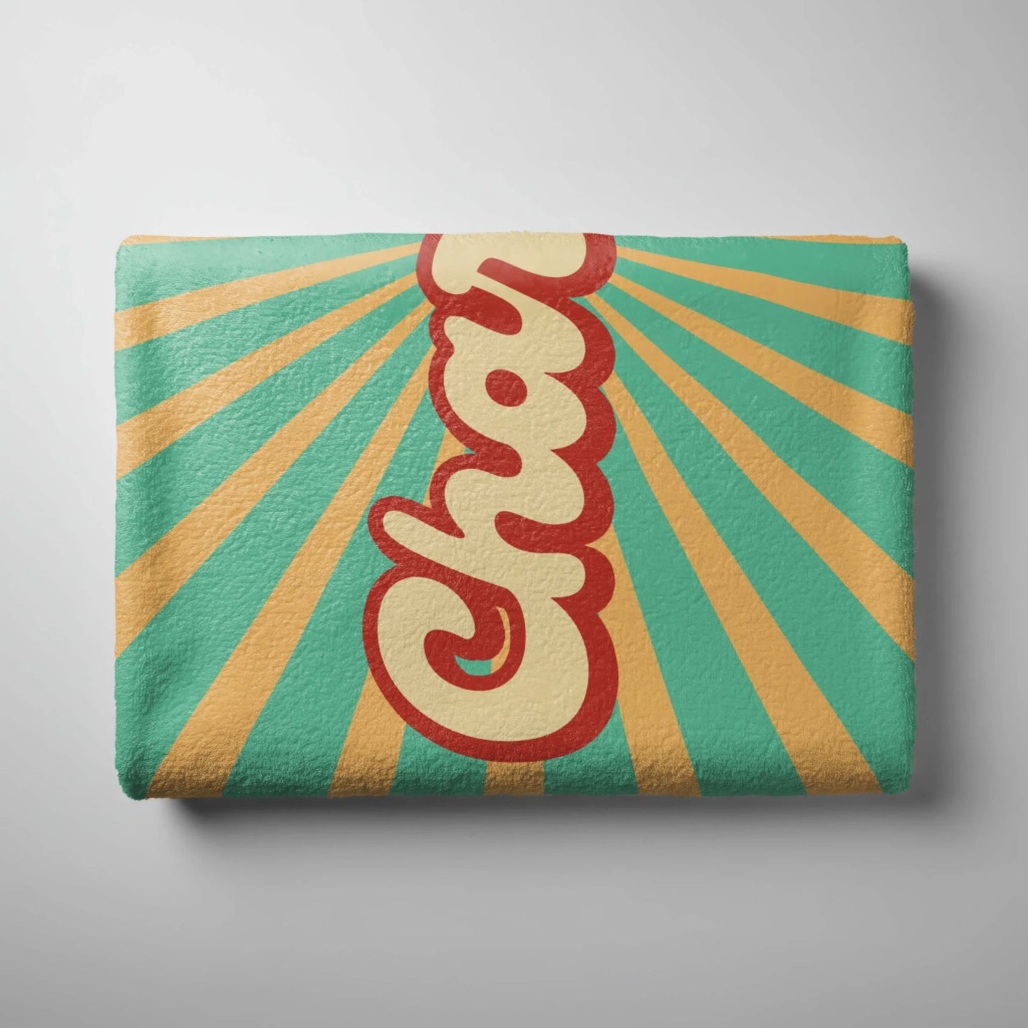 Folded custom beach towel with retro sunburst pattern and personalized name text in a stylish vintage font.