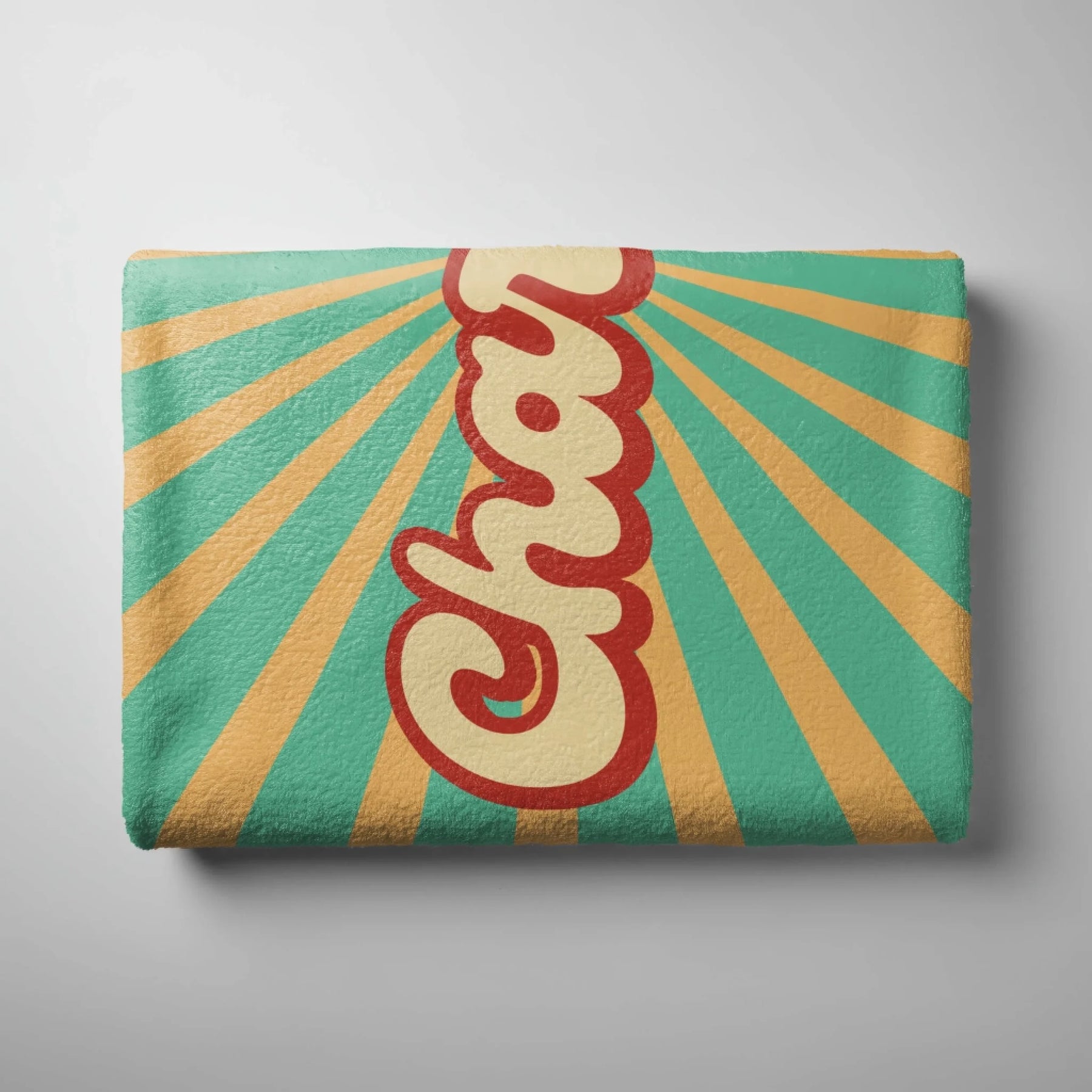Folded custom beach towel with retro sunburst pattern and personalized name text in a stylish vintage font.