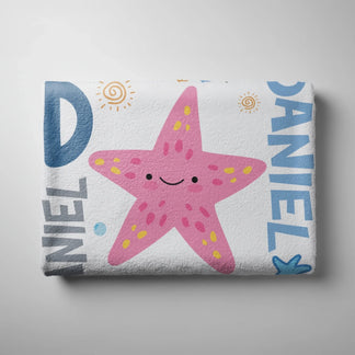 Folded custom beach towel with a pink starfish design and Daniel text, ideal for personalized kids summer gifts.