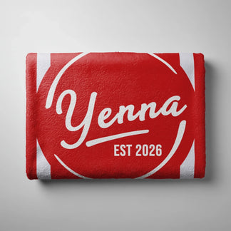 A neatly folded red and white striped beach towel featuring custom text Yenna and EST 2026 on a neutral background.