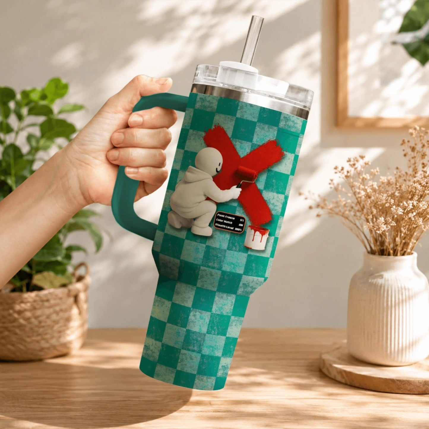 Custom gaming tumbler with a character painting a red X and stats against a teal checkered pattern