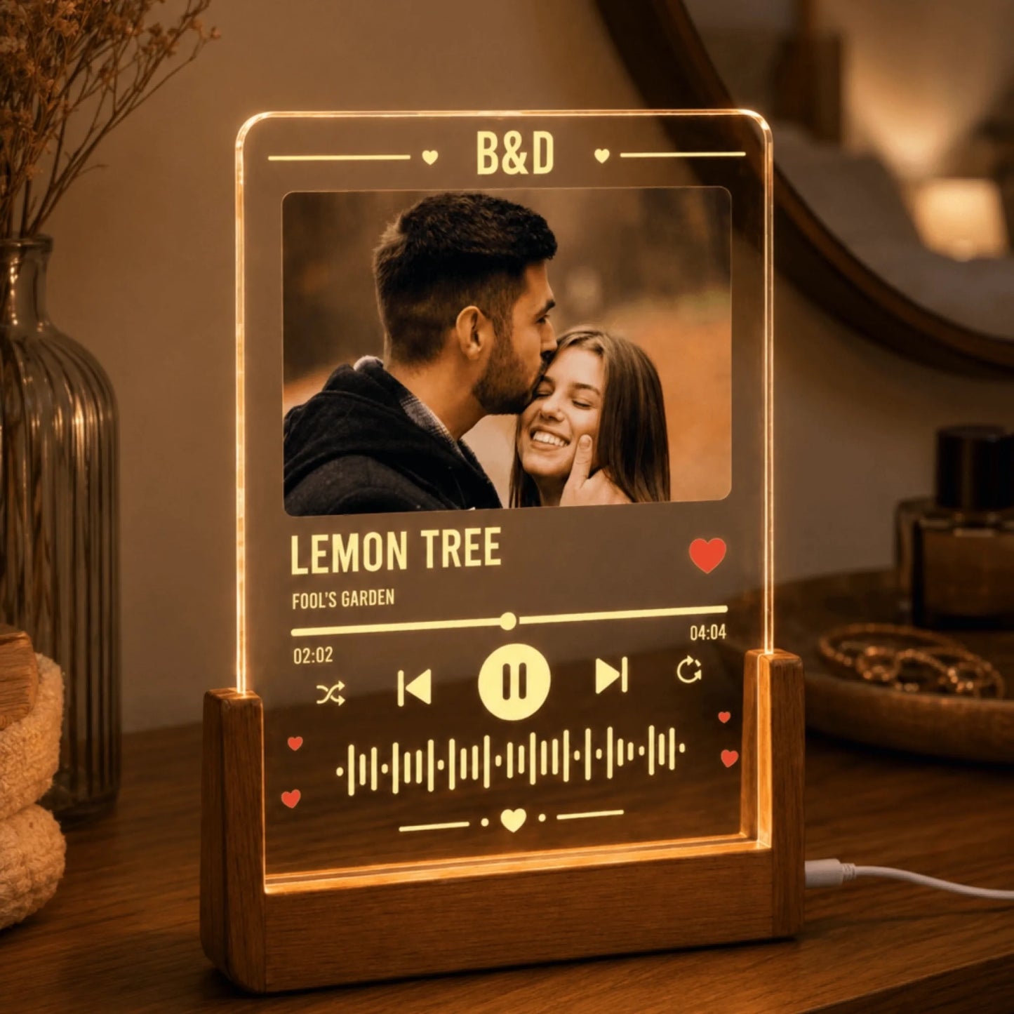 Close-up of a personalized acrylic music player plaque with warm LED lighting on a wooden base.