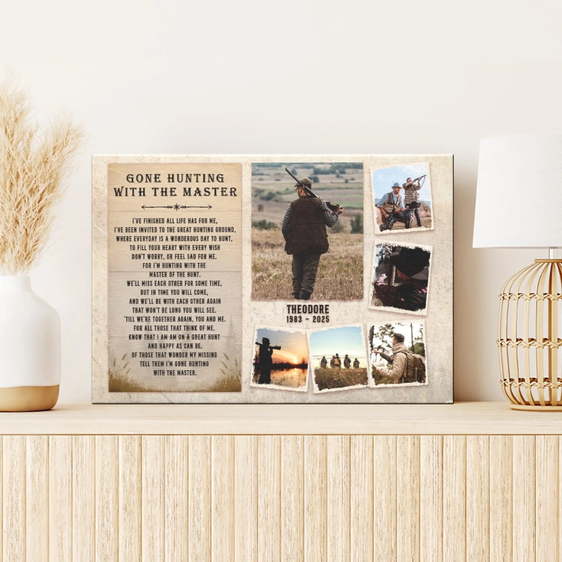 A canvas print with a hunting-themed poem and photo collage, displayed on a light wooden console table with decorative grass and a lamp.