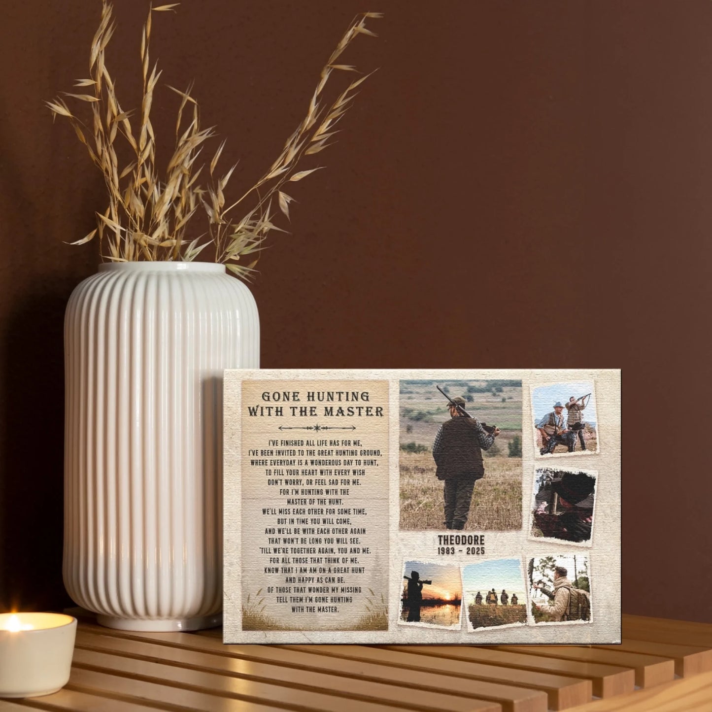 A canvas print featuring hunting photos and text, displayed on a wooden table next to a white vase with dried foliage and a candle.