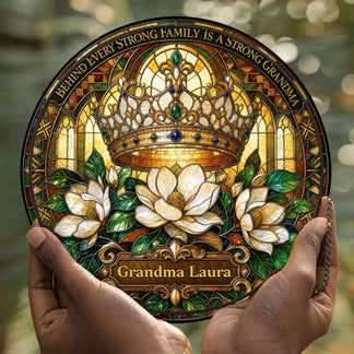 Hands holding a custom Grandma Laura acrylic suncatcher with a crown and magnolia floral stained glass style theme.