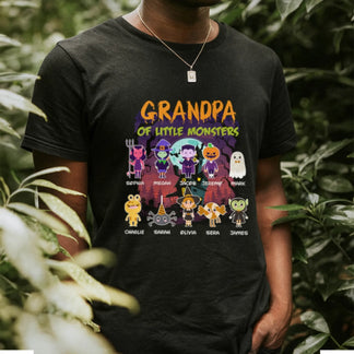A man wears a black personalized Halloween t-shirt featuring a Grandpa of Little Monsters design with custom names.