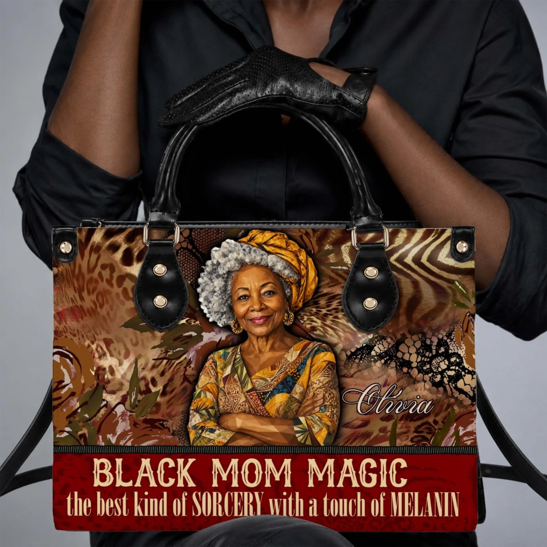 Close up of a person holding a custom Black Mom Magic handbag featuring a name and elegant African American art