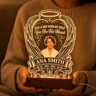 Person holding a custom memorial LED night light with engraved angel wings and a photo of Ana Smith.