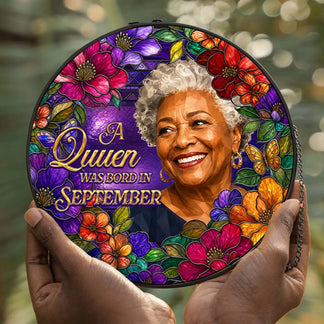 Hands holding a personalized September queen acrylic suncatcher decorated with colorful stained glass flowers.