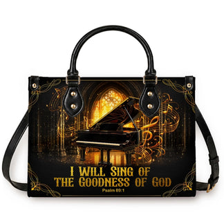 Black leather tote bag featuring a piano illustration and I Will Sing of the Goodness of God scripture verse design.