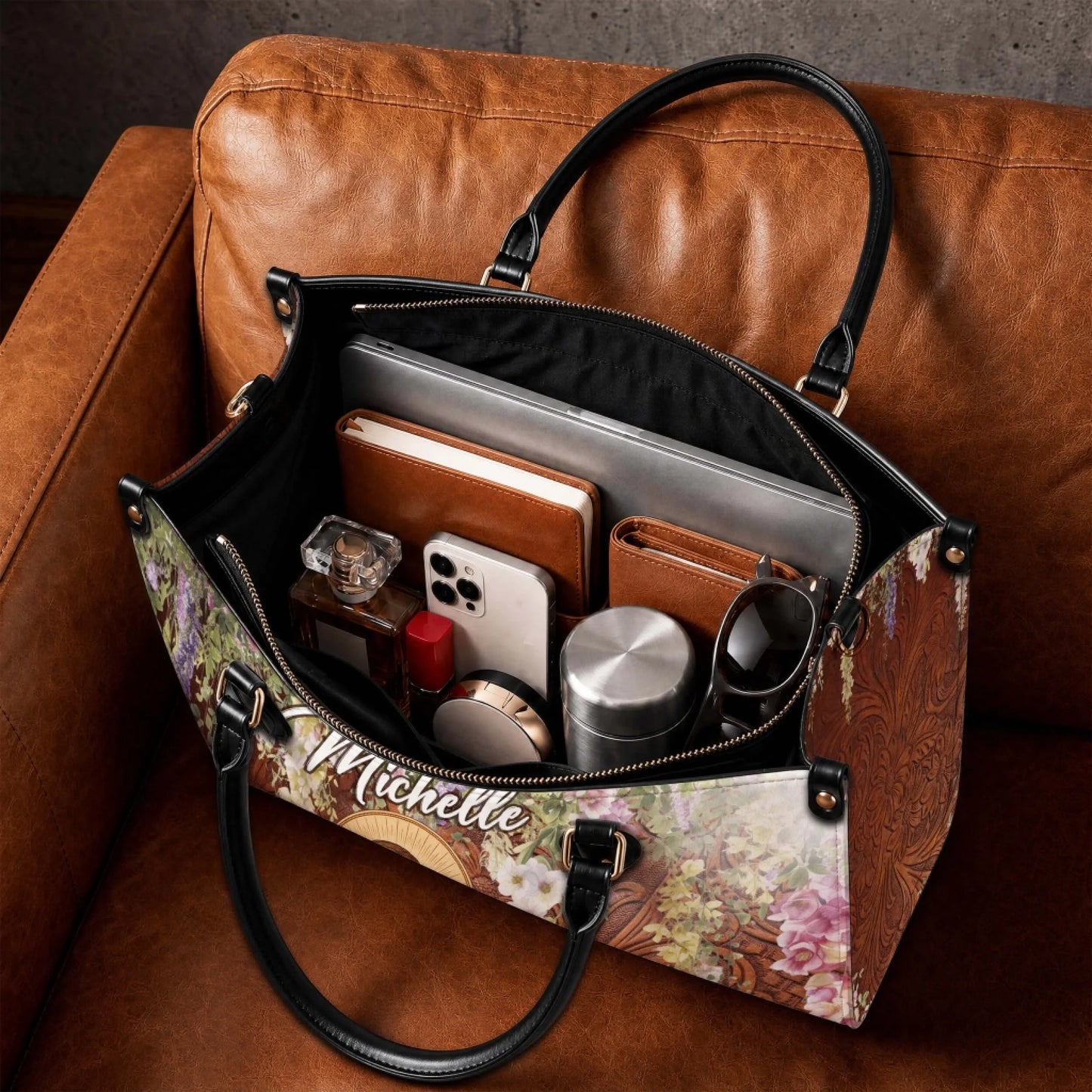 The spacious interior of a personalized Jesus and lamb handbag, shown packed with personal items like a laptop and wallet.