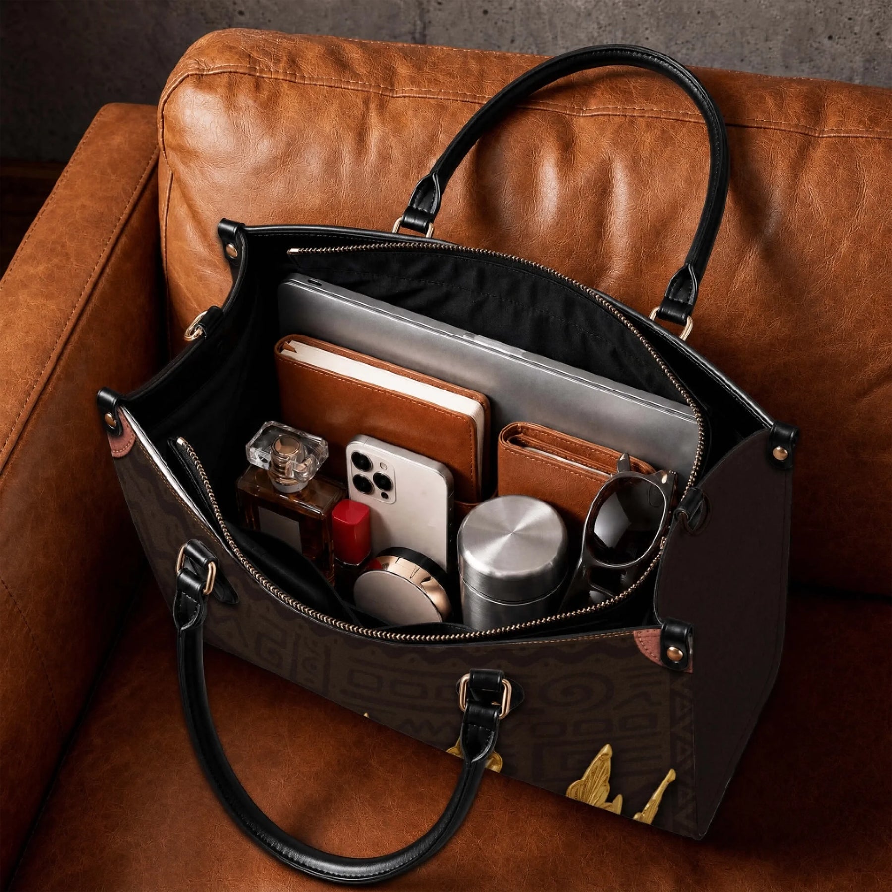 Spacious interior of a personalized mother handbag filled with daily essentials including a laptop, wallet, and phone.