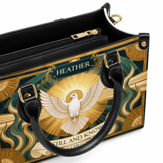 Open interior of a personalized religious handbag featuring a dove design with a gold zipper and organized compartments.