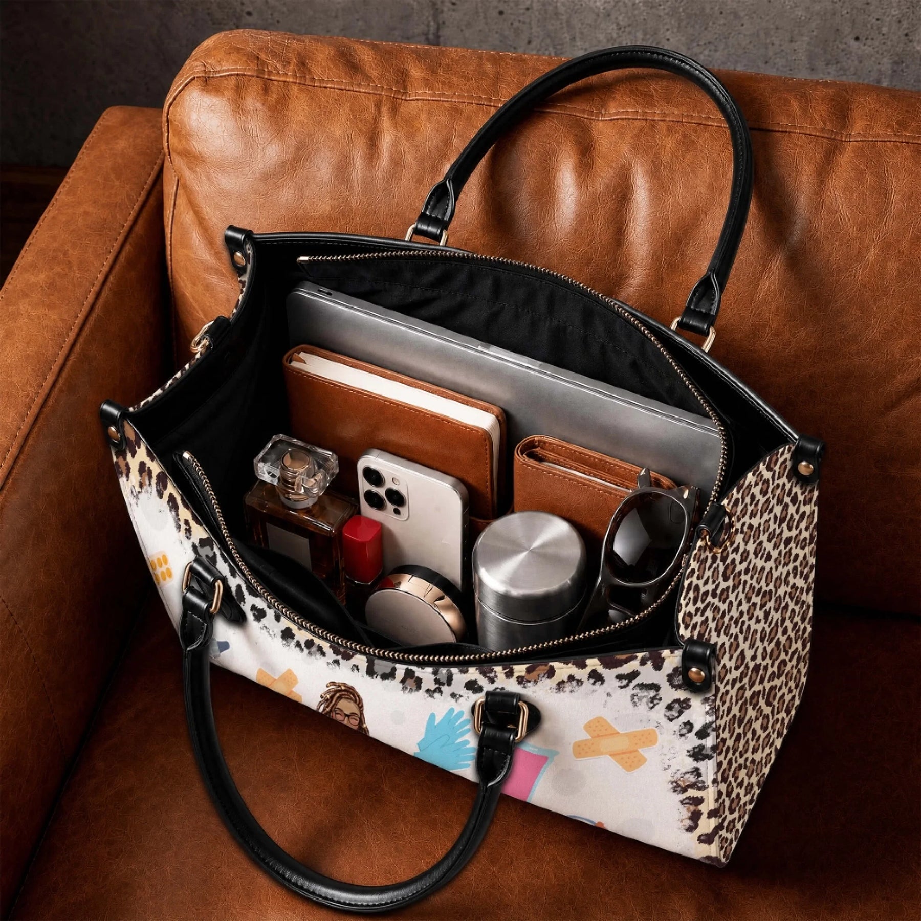 Inside view of a spacious leopard print nurse bag organized with a laptop, wallet, phone, and daily essentials.