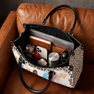 Inside view of a spacious leopard print nurse bag organized with a laptop, wallet, phone, and daily essentials.