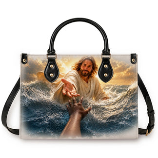 A religious themed handbag featuring a depiction of Jesus reaching out to a hand, perfect for a faith-based gift.