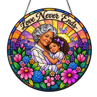 A beautiful stained glass suncatcher featuring a grandmother and granddaughter with flowers and the quote Love Never Ends.