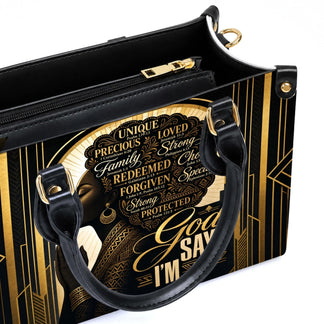 Interior view of a black and gold luxury handbag featuring a praying woman print with various Bible verse quotes.