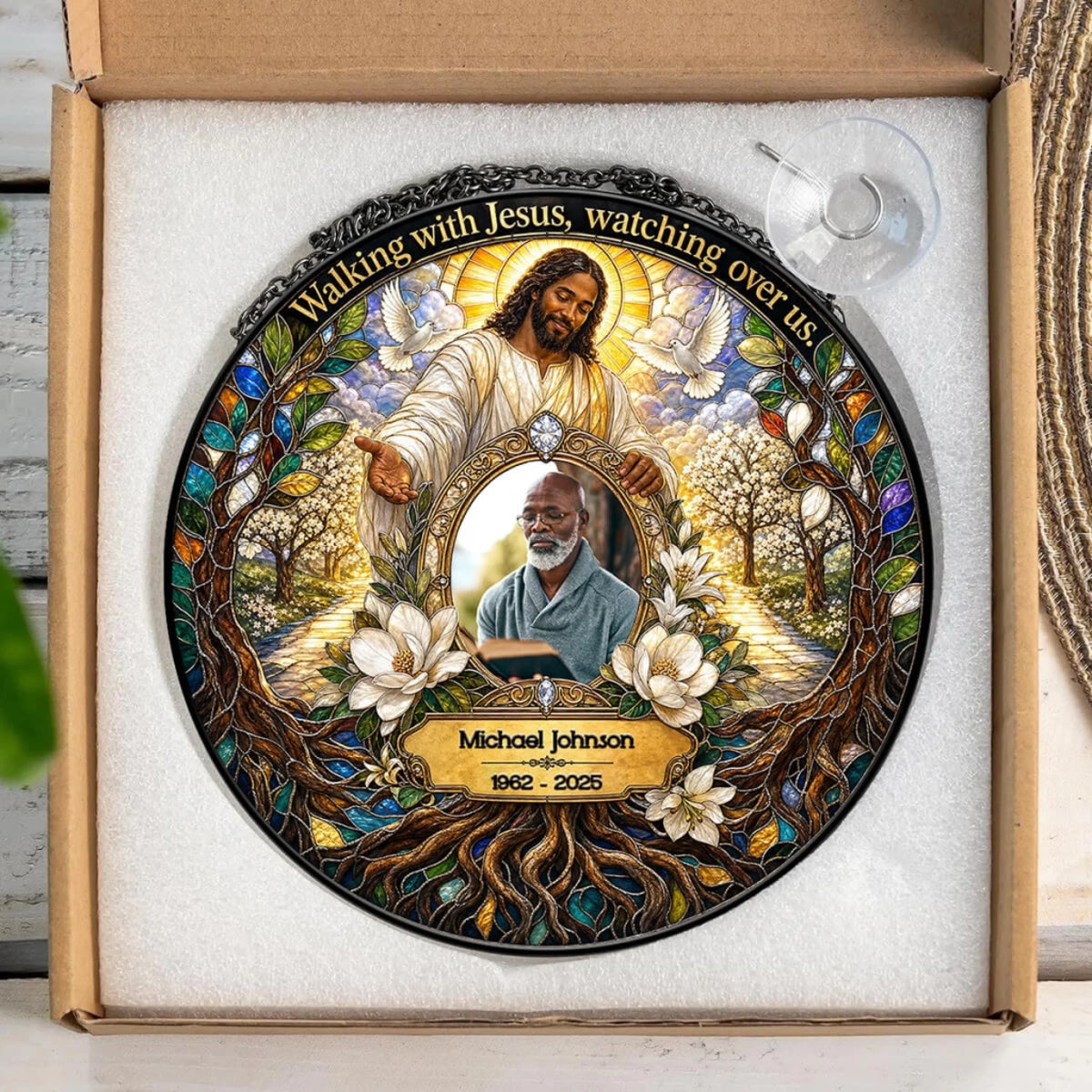 Custom memorial suncatcher with a photo of a loved one and Jesus in a gift box with a hanging suction cup attachment.