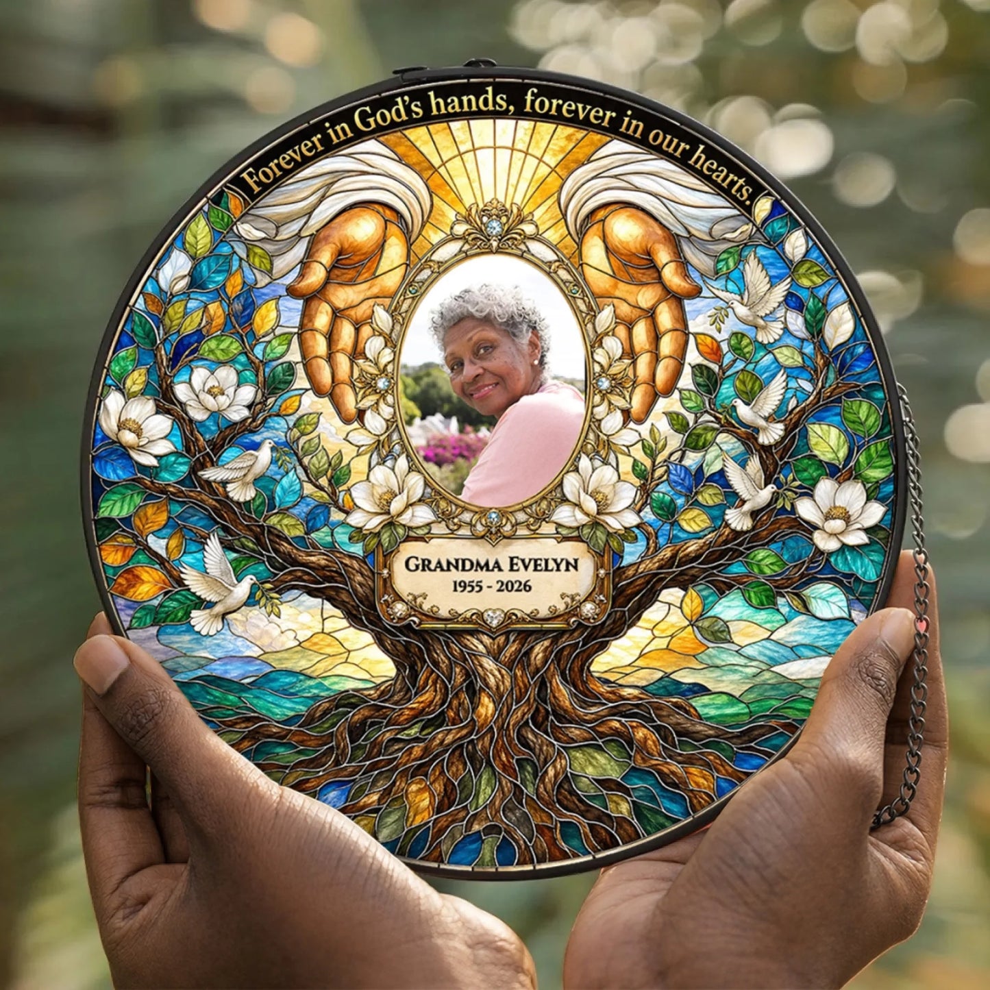 Holding a personalized stained glass memorial suncatcher with Grandma Evelyn photo and memorial tree design.