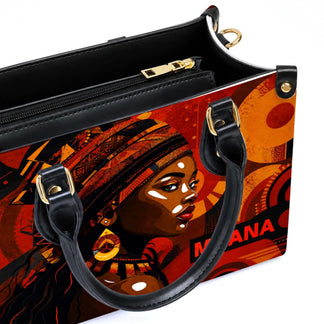 Close-up of a high-quality PU leather handbag with a striking African woman portrait design and gold-tone zippers.