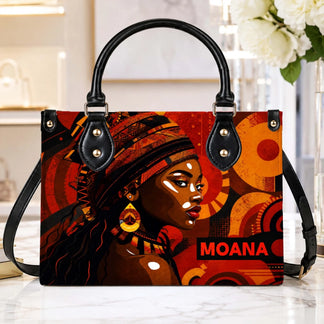Elegant handbag featuring a vibrant portrait of an African woman with abstract orange and red patterns and Moana text.