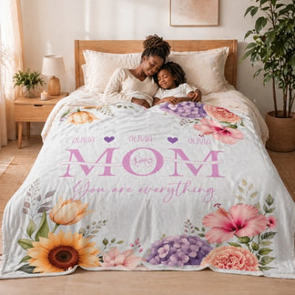 Cozy personalized floral blanket with the name Olivia for Mom on a bed in a warm bedroom setting, perfect for gifts.