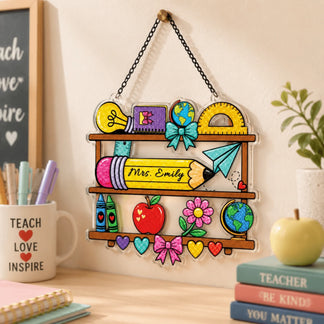 Personalized Mrs. Emily teacher shelf ornament displayed on a wall near a desk, books, and inspirational decor.