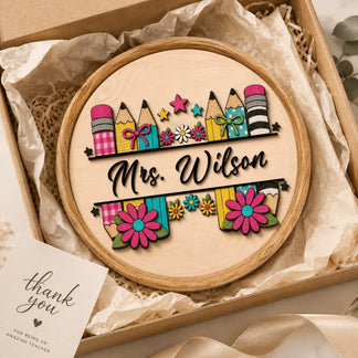Round personalized wooden sign for teachers with pencil and flower artwork, presented in a gift box with thank you.