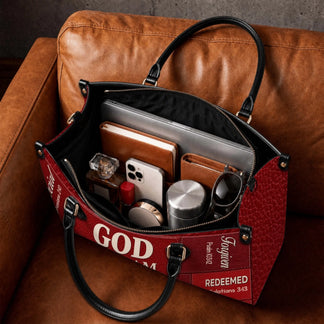 The interior of a personalized religious handbag displaying organized daily essentials, including a laptop and notebook.