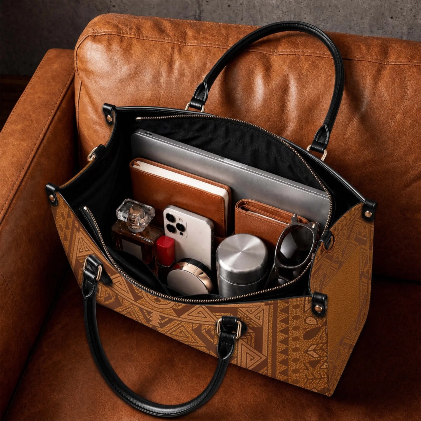 Interior view of a spacious brown leather tote bag packed with a laptop notebook phone and everyday essentials.