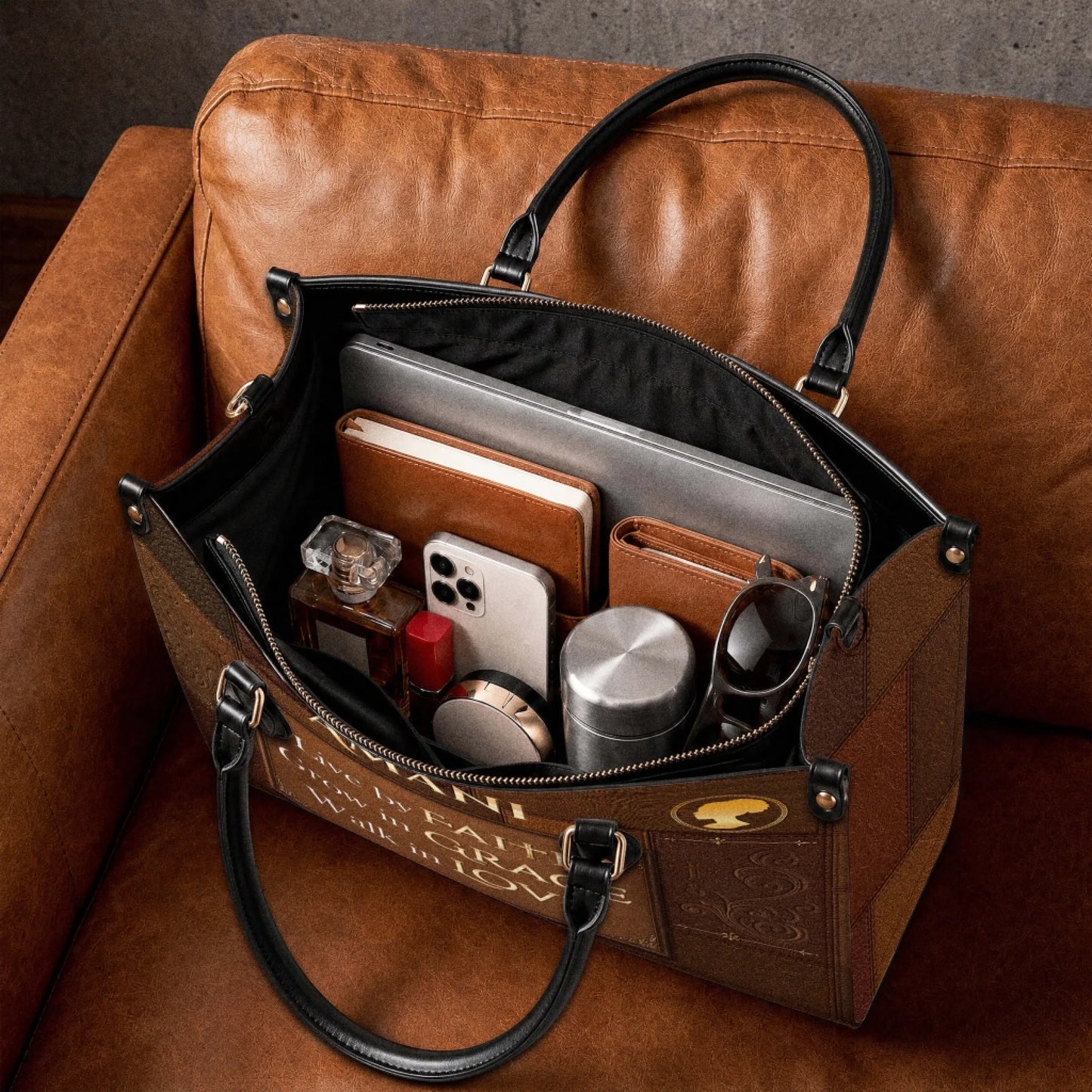 The spacious interior of a brown personalized Christian faith tote bag packed with everyday items like a laptop, phone, and wallet.