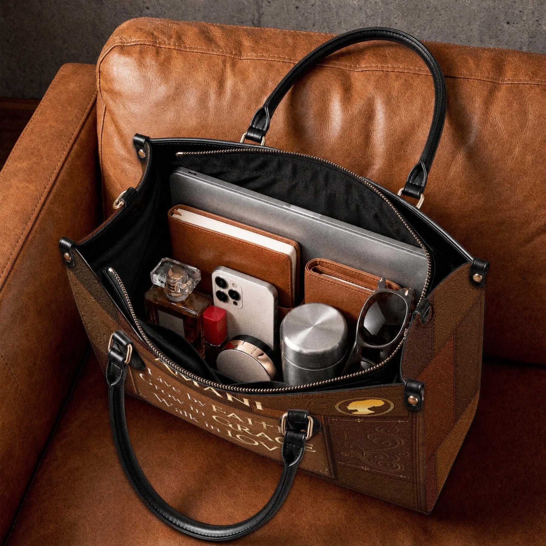 The spacious interior of a brown personalized Christian faith tote bag packed with everyday items like a laptop, phone, and wallet.