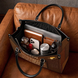 The spacious interior of a brown personalized Christian faith tote bag packed with everyday items like a laptop, phone, and wallet.