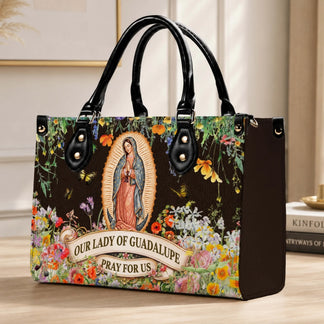 Elegant structured handbag displaying Our Lady of Guadalupe art with colorful wildflower accents and butterflies.