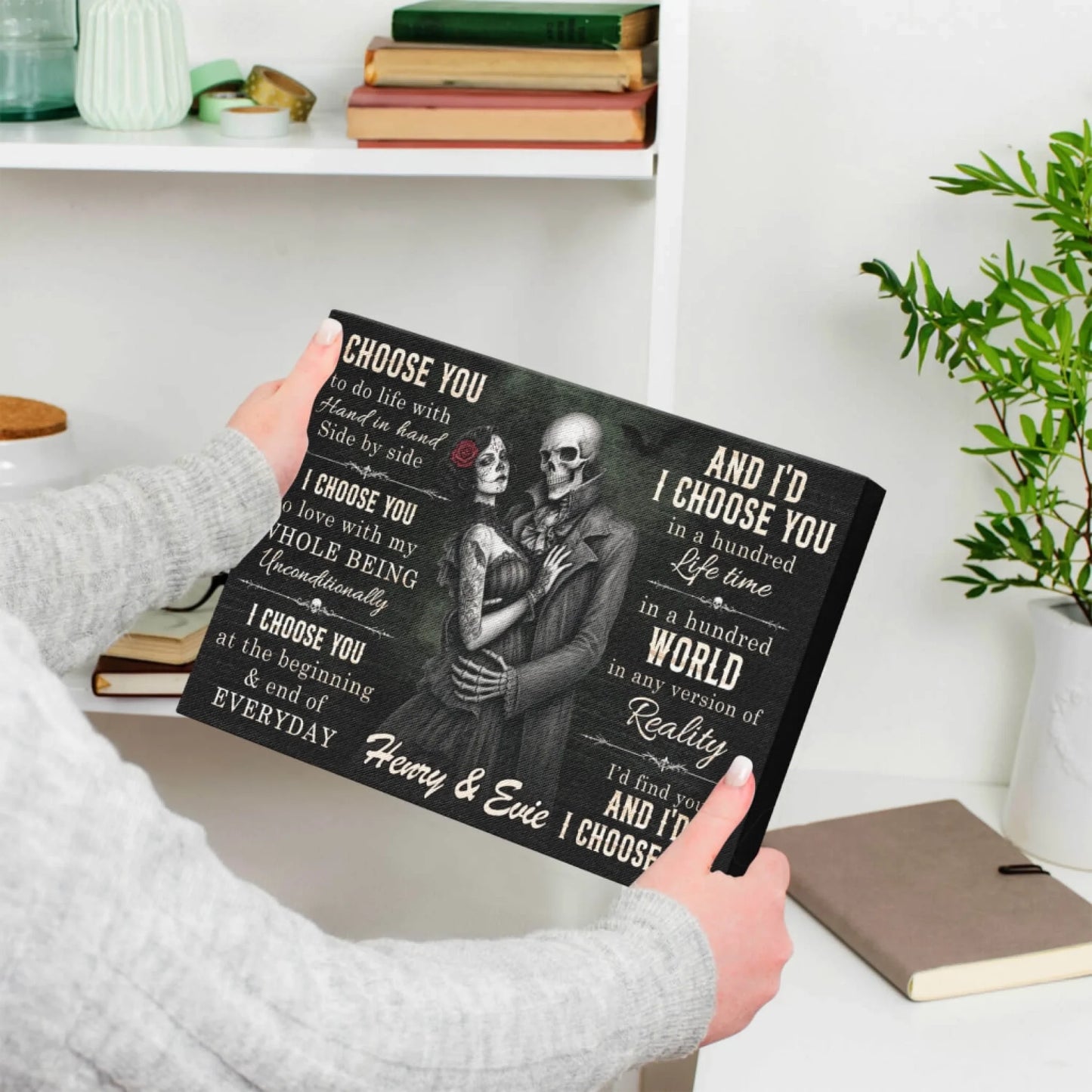 Person holding a romantic personalized skeleton couple canvas print with custom names Henry and Evie as a wedding gift.