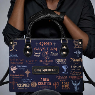 Person in black clothing and leather gloves holds a personalized Ruby Michelle handbag featuring inspirational quotes.