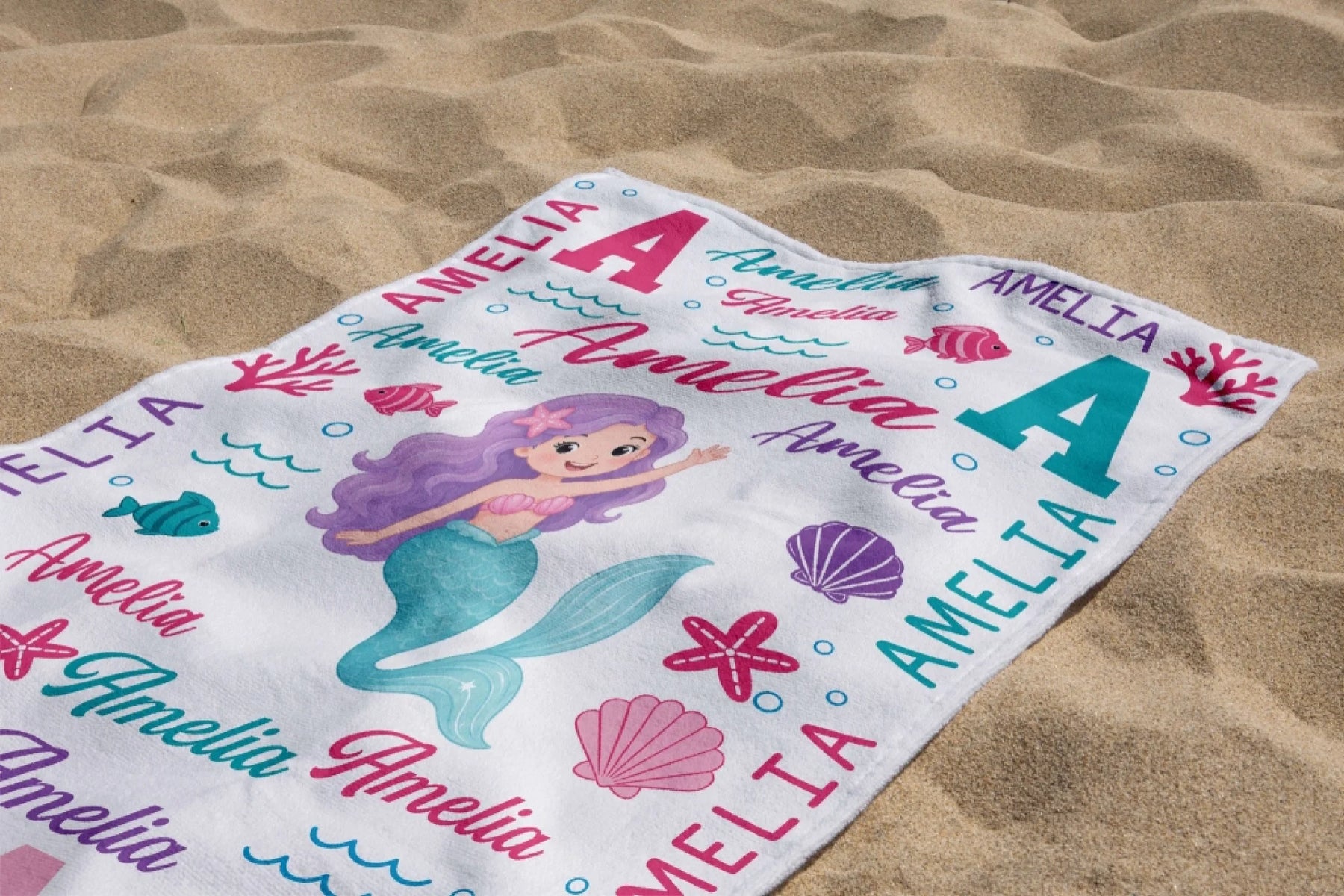 Custom name mermaid beach towel with pink sea shell design, ideal as a cute personalized birthday gift for girls.