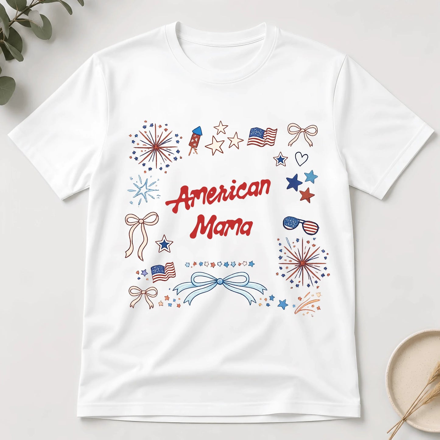 White t-shirt with 'American Mama' text and patriotic graphics on a light gray background