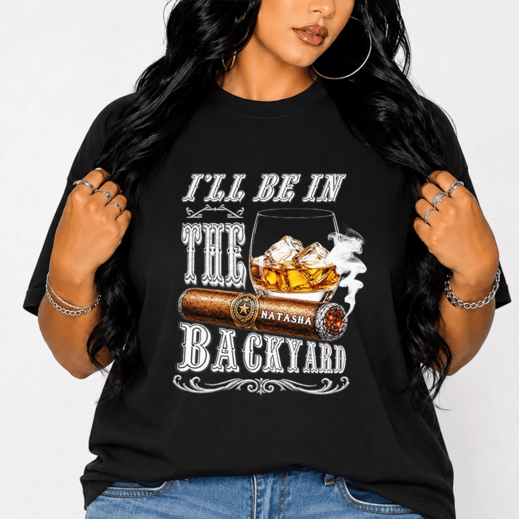 A black t-shirt for women featuring a graphic of a whiskey glass and cigar with the custom name Natasha printed.