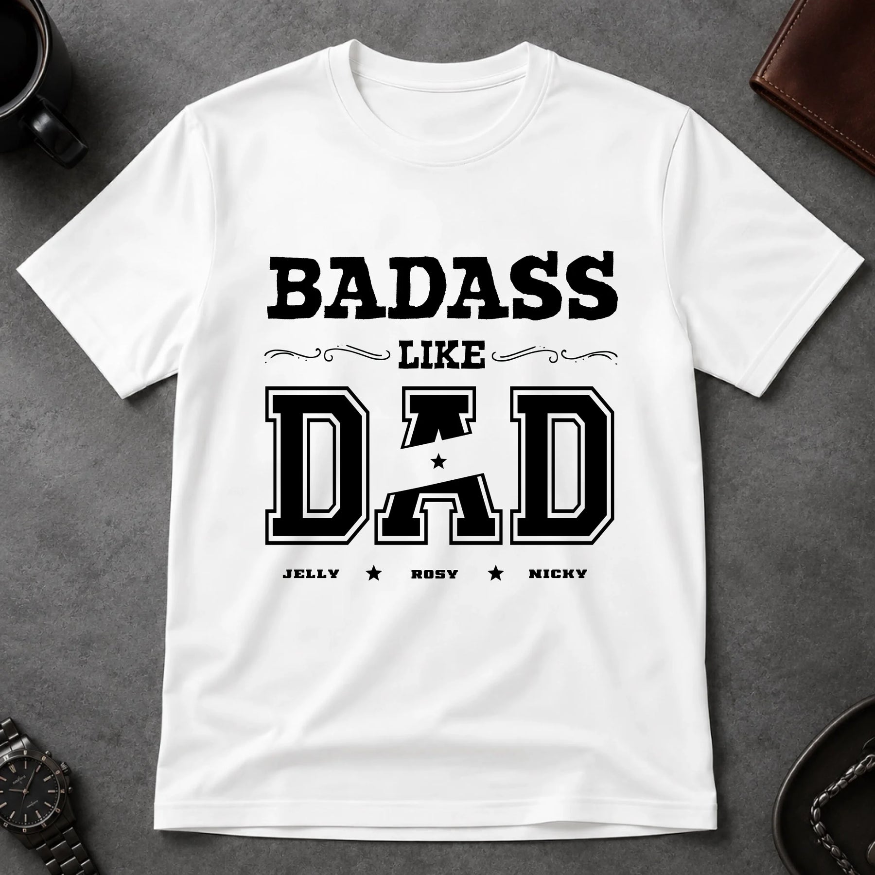 White t-shirt with 'BADASS LIKE DAD' text on a gray surface