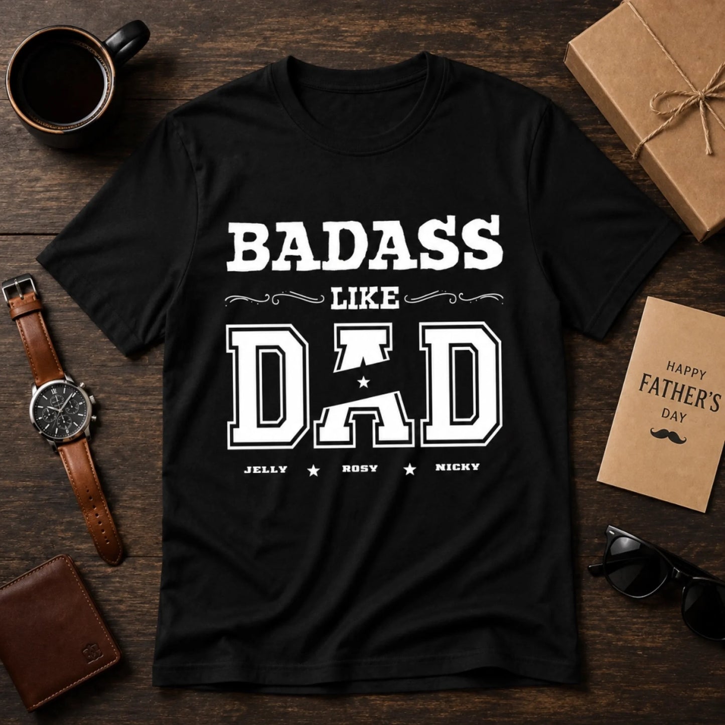 Black t-shirt with 'BADASS LIKE DAD' text on a wooden surface with Father's Day items.