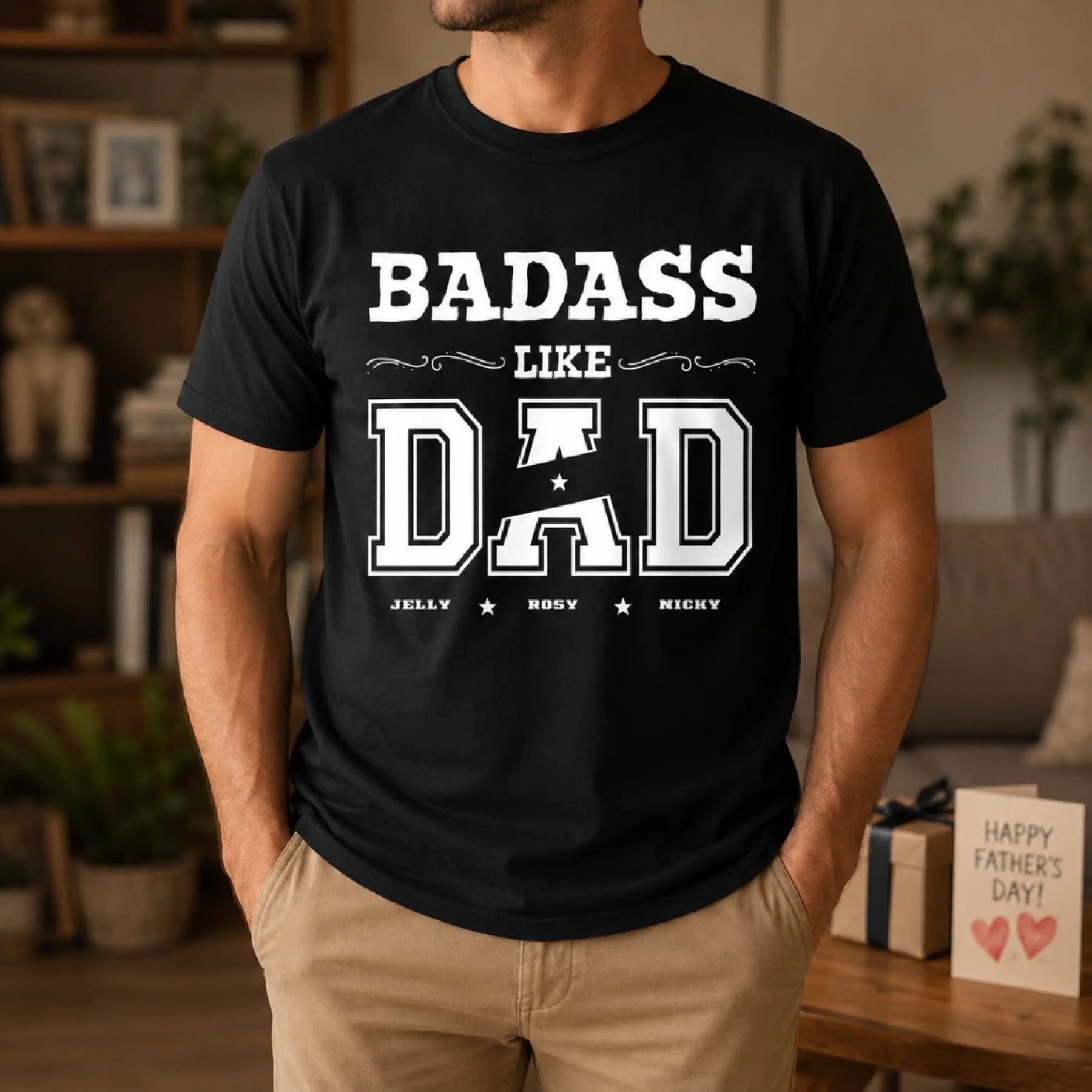 Person wearing a black t-shirt with 'BADASS LIKE DAD' text in a home setting.