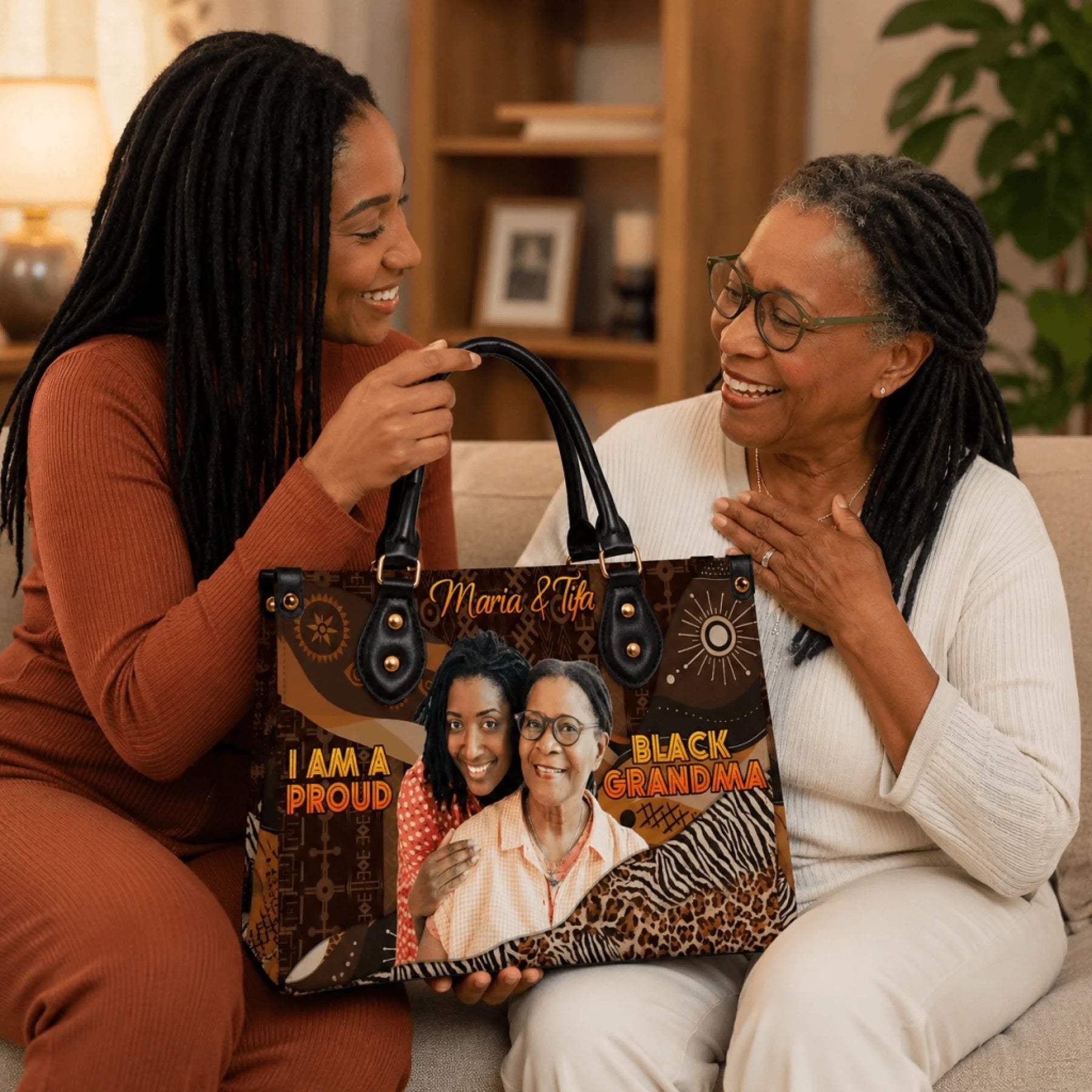 Two women smiling and holding a custom printed handbag with a portrait photo and the text Maria Tifa Black Grandma.