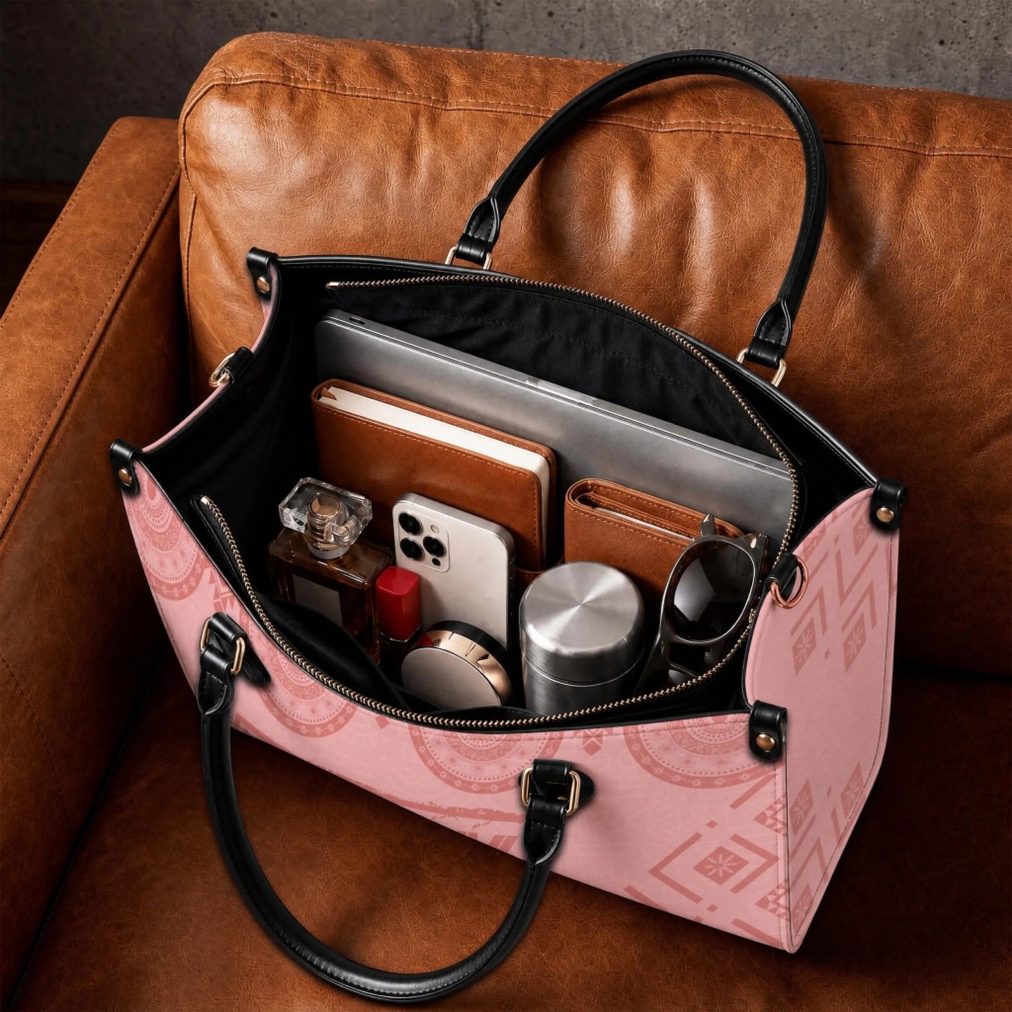 An open view of a personalized Black Grandma Magic tote bag filled with daily essentials like a laptop notebook and perfume.