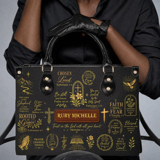 Black handbag with custom name Ruby Michelle and elegant gold religious prints, perfect for a faith inspired gift.