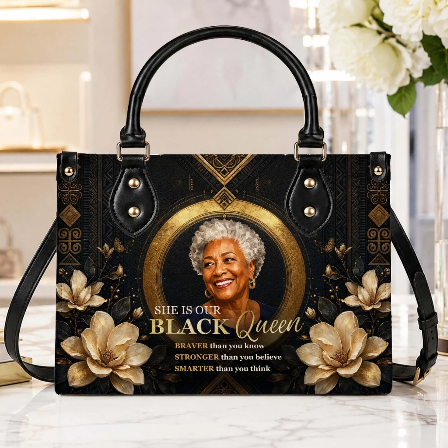 Stylish PU leather handbag displaying a portrait of a Black queen with gold floral accents and an adjustable strap.