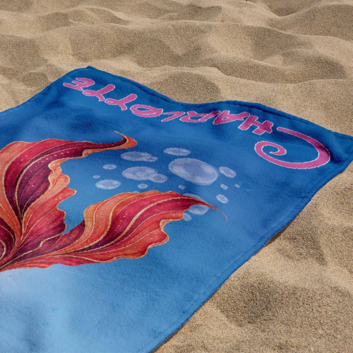Custom Charlotte beach towel with a vibrant red and blue mermaid tail design for kids who love ocean themes.