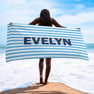 A personalized beach towel featuring blue and white stripes with the custom name Evelyn displayed prominently.
